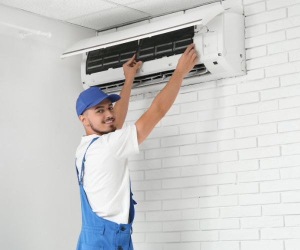 JGA Premier technician servicing a split air conditioner in a Dubai home